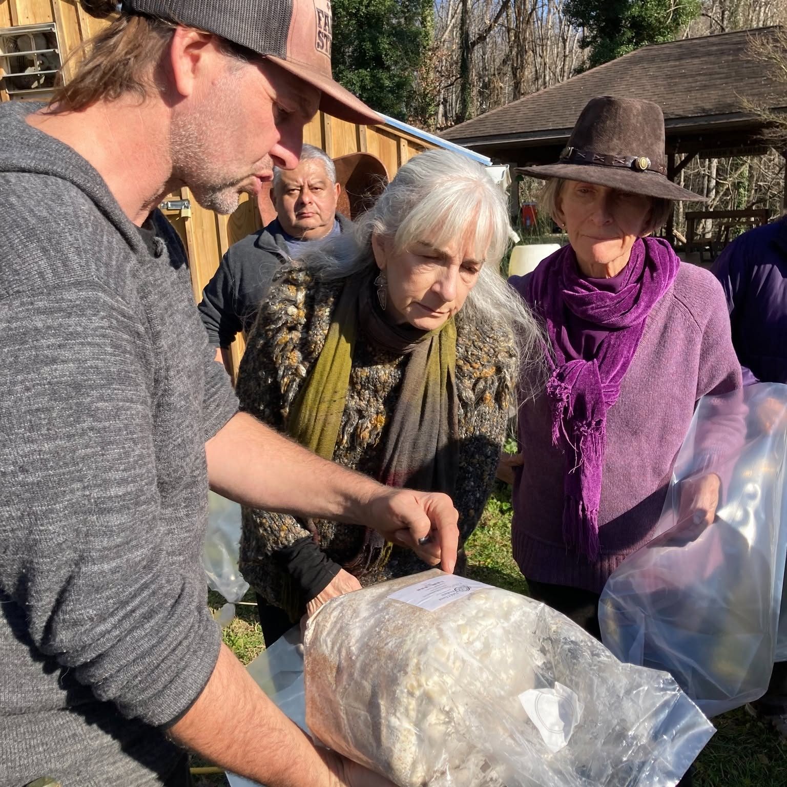 Chris Parker pointing out what is happening inside a grow bag while a student looks on
